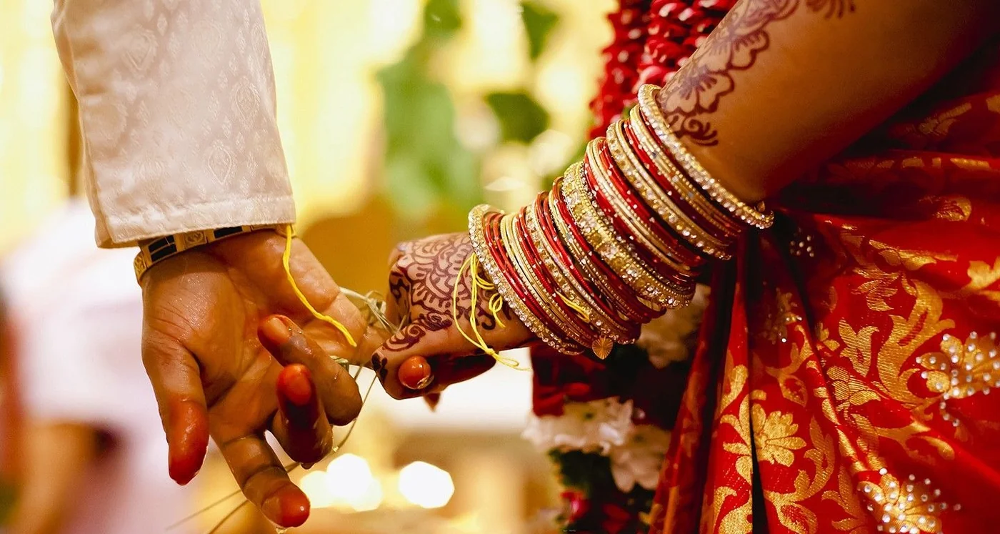 An Indian bride and groom holding hands
